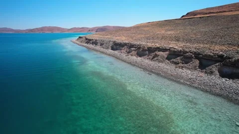 Eroded pebble bank above transparent Yamdrok Lake water Vidéo 345886006