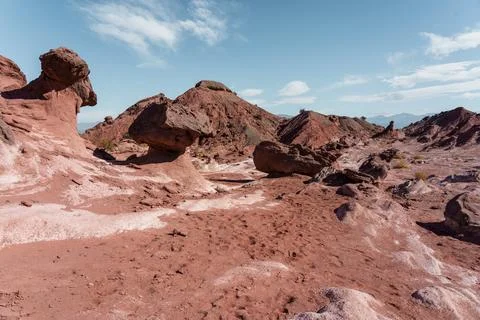 Eroded red rock formations in arid desert valley Stock Photos