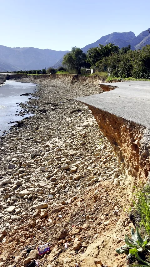Eroded riverbank after heavy storm floodwaters carved away tar road Vídeo Stock 345994975