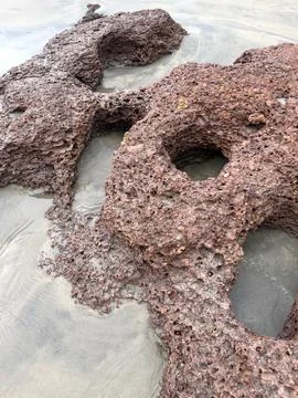 Eroded Rock Formation on Sandy Beach Stock Photos