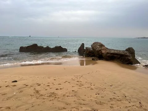 Eroded rocks emerging from the ocean on a cloudy day Stock Photos