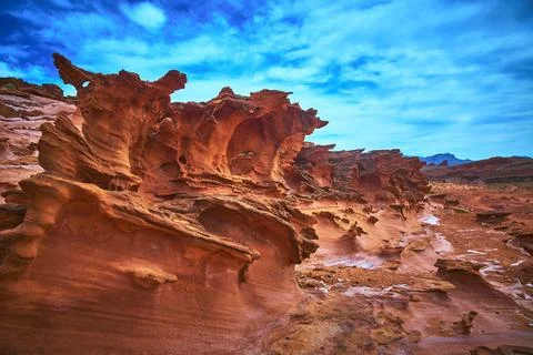 Eroded Sandstone Formations and Dramatic Desert Landscape Under Vibrant Blu.. Stock Photos
