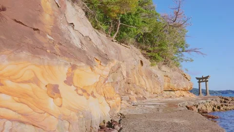 Eroded sandstone rock wall with beautiful wave patterns leading to Torii gate Stock Footage 340749782