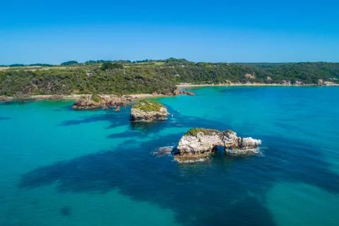 Eroding rocky outcrops in shallow turquoise ocean water at Walkerville, Victo Stock Photos