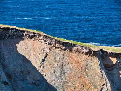 Eroding soil, subsoil and bedrock shown on sheer cliffs near Uyea Foto stock