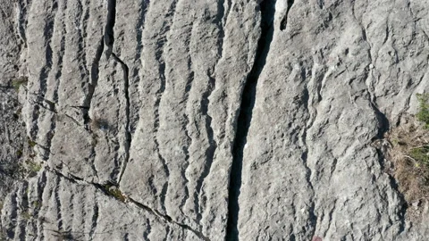 Erosion of bare wrinkled rock - texture of rough stone with grooves and furrowed Stock Footage 232437675