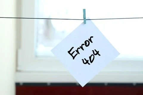 Error 404. Note is written on a white sticker that hangs with a clothespin on Stock Photos
