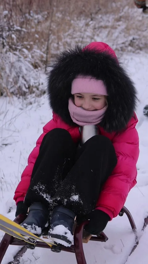 Ertical video. Mother pulling a sled with a little girl, on a walk on a winter Video stock 321306540