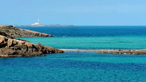 Es Grau, view over coastline to a lighthouse, Menorca Stock Footage 73239186