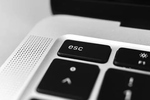 Esc key and button on keyboard. Escape sign close-up. Modern laptop Stock Photos