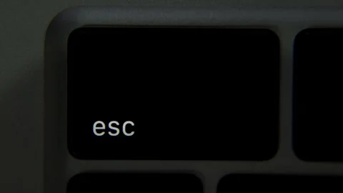 Esc label on a laptop key lights up as backlight activates the symbol in a close Stock-Footage 330522818
