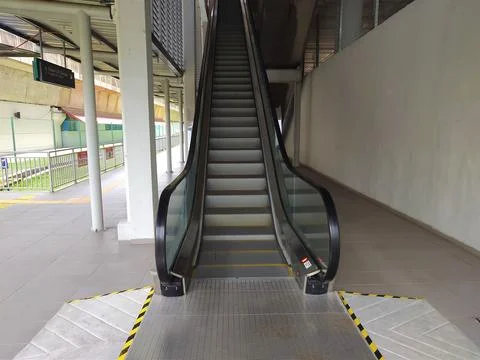 Escalator connects the ground floor to the platform level. Stock Photos