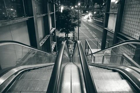 An escalator down to a empty dark street. Stock Photos
