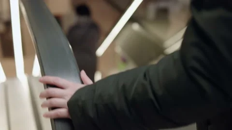 Escalator elevator black handrail moving down female hand holding while going Stock Footage 218506891