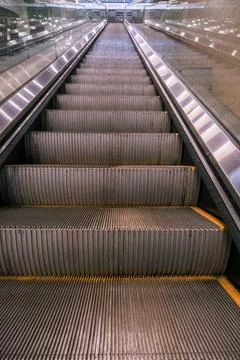 The escalator is empty and has a yellow stripe Stock Photos
