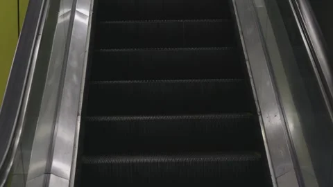 Escalator going up in a building during the day, showing the steps and silver Video stock 325186004