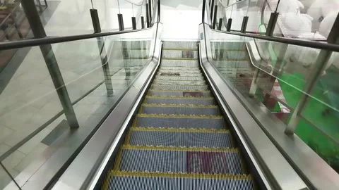 The escalator machine goes down. Go down slowly. In a busy shopping center. Stock Footage 247913661