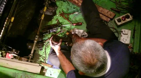 Escalator maintenance - Old mechanic man attaching a new roller for an escalator Stock Footage 39567476