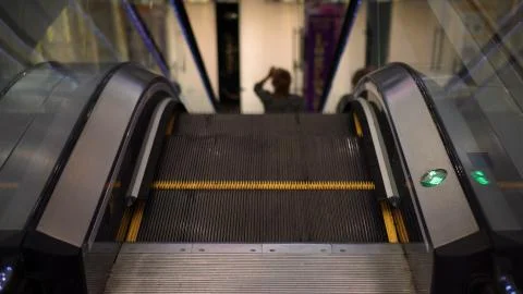 Escalator in the mall, low light, green arrow Stock Photos