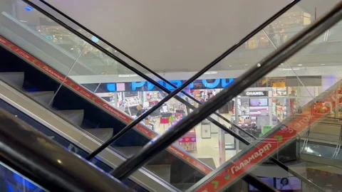 The escalator in the mall moves down against the backdrop of shops Stock Footage 180710070
