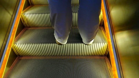 The escalator steps moving up and legs of a man upstairs Stock Footage 108773281