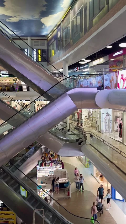 Escalators and storefronts inside a modern shopping mall Stock Footage 343732291