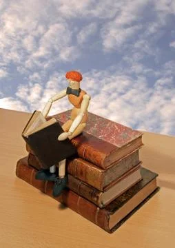 The escape by the reading, reader sat on a shelf travelling in the sky Stock Photos