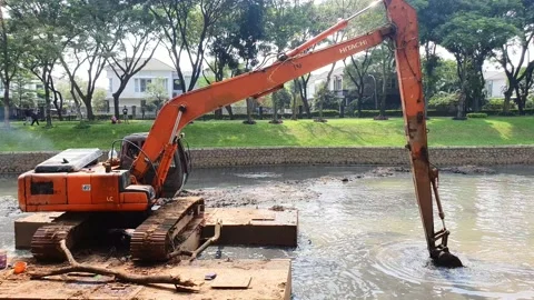 The Escavator digs the sediment in the river preventing flood Stock Footage 218213667