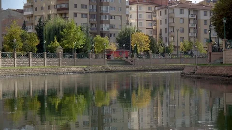 Eskisehir, Turkey - September 2018: Reflection of trees, city buildings in water Stock Footage 99707014