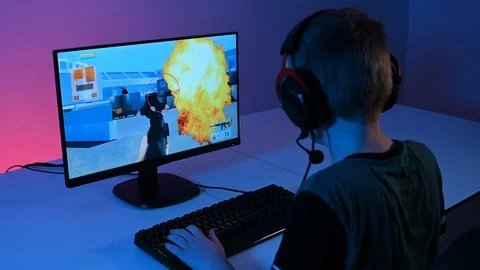 Esport gaming on pc with kid sitting in front of pc with headset Stock Footage 100725968