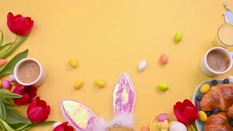 Espresso coffee in bright cups, Easter chocolate eggs, pink bunny ears Video stock 146867916