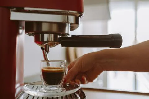 Espresso coffee from coffee machine in transparent glass cup Stock Photos