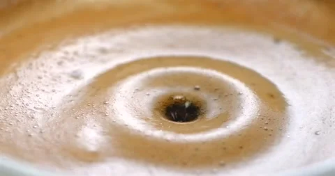 Espresso coffee drop creating a splash and ripple in crema super slow motion Stock Footage 342590985