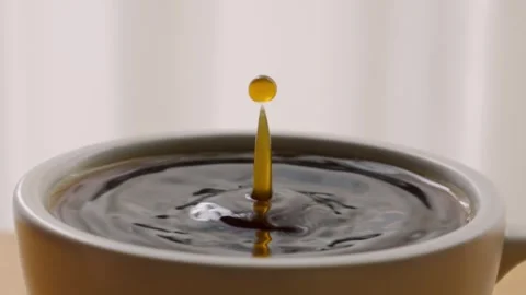 Espresso coffee drop into the filled Cup in slow motion Stock Footage 254943475
