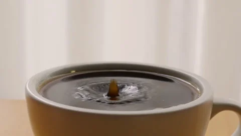 Espresso coffee drop into the filled Cup in slow motion Stock Footage 254943532
