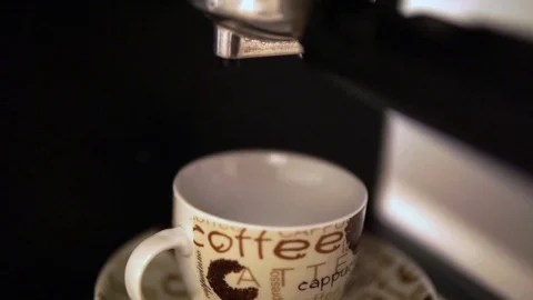 Espresso coffee made with coffee machine, coffee falls into a cup from porcelain Stock Footage 99843202