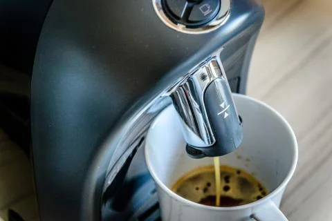 Espresso coffee maker machine making and flowing out espresso into a white ch Stock Photos