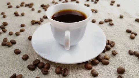 Espresso coffee in a small white cup on a light background of a textile napkin Video stock 150938960