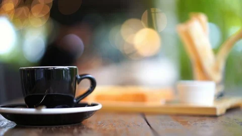 Espresso coffee table with with blurred green leaves and light bokeh background Stock Footage 93332855