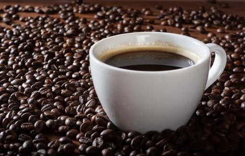 Espresso coffee on the table with coffee beans. Scattered coffee beans on a w Foto stock