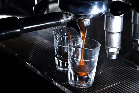 Espresso machine brewing a coffee in bar. Coffee pouring into shot glasses Foto stock