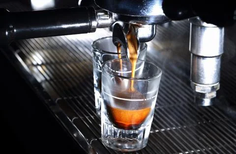 Espresso machine brewing a coffee in bar. Coffee pouring into shot glasses Foto stock