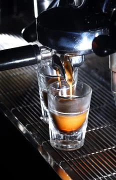 Espresso machine brewing a coffee in bar. Coffee pouring into shot glasses Stock Photos