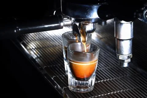 Espresso machine brewing a coffee in bar. Coffee pouring into shot glasses Stock Photos
