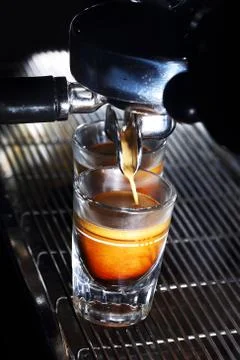 Espresso machine brewing a coffee in bar. Coffee pouring into shot glasses Stock Photos
