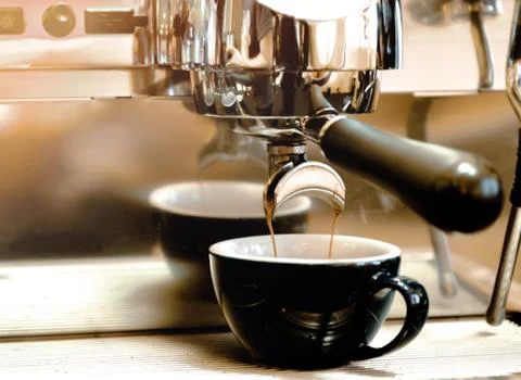 Espresso machine brewing a coffee. Coffee pouring into glasses in coffee shop Stock Photos