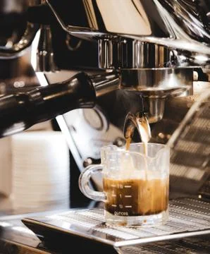 Espresso machine brewing a coffee. Coffee pouring into glasses in coffee shop Stock Photos