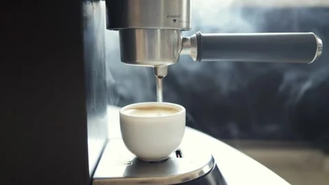Espresso machine brewing fresh coffee into a white cup with steam rising Stock Footage 339000277