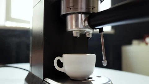 Espresso machine brewing a rich coffee into a white cup with steam rising Stock Footage 339000676