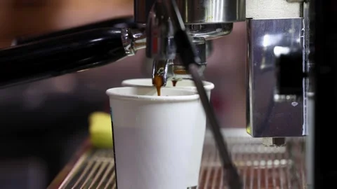 Espresso machine dispensing coffee into two paper cups during extraction process Stock Footage 336468772